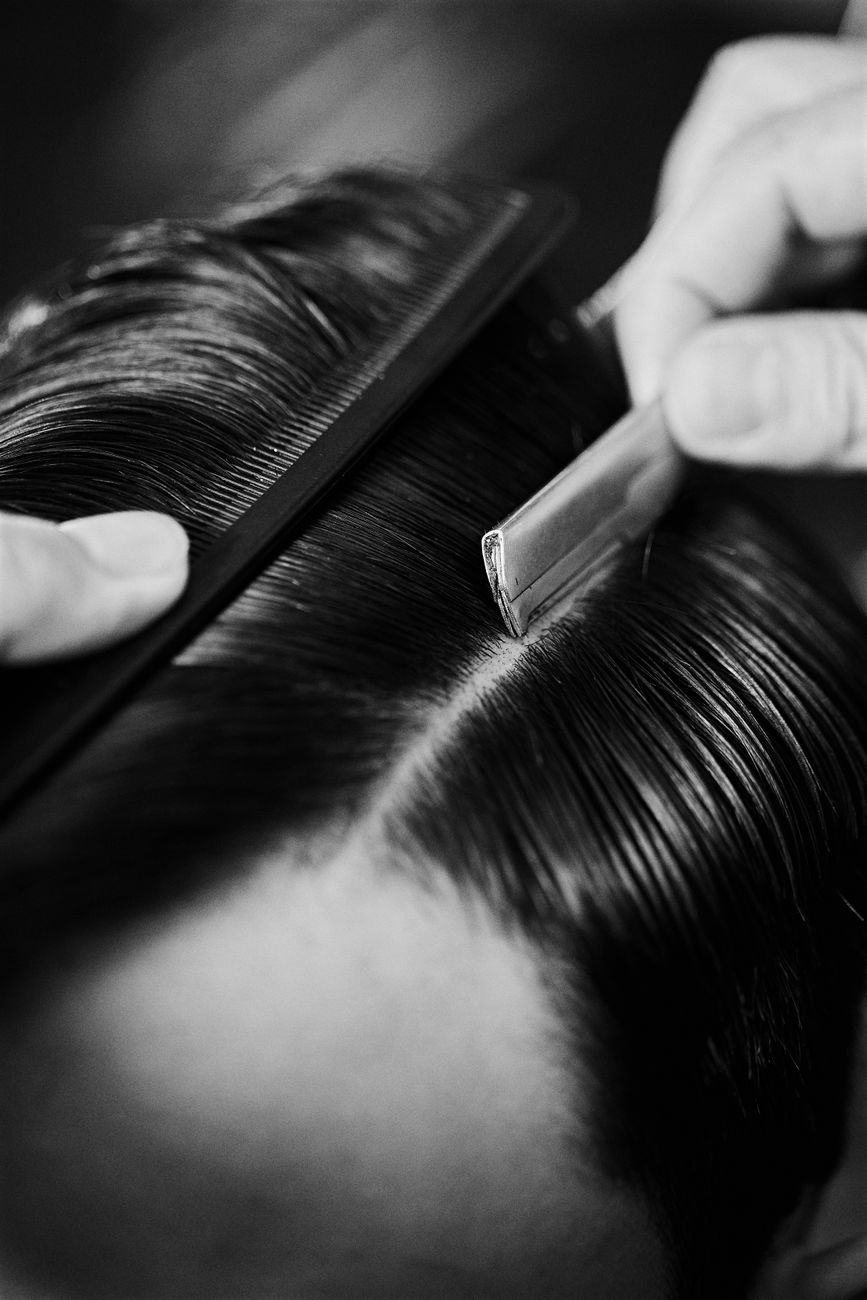 Barbeiro profissional realizando corte masculino preciso